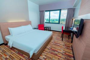 una camera d'albergo con un letto e una televisione di Harbour View Hotel a Kuching
