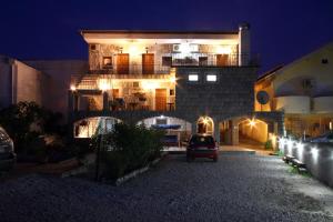 a building with a car parked in front of it at night at Apartments Savina in Budva