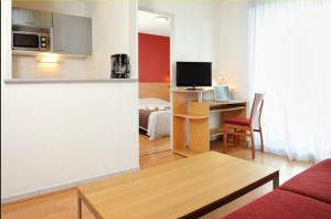 a living room with a couch and a table in a room at Séjours & Affaires Lyon Park Lane in Lyon