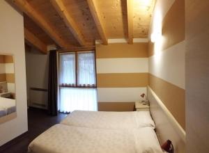 a bedroom with two beds and a window at Agritur Maso Barco in Faedo