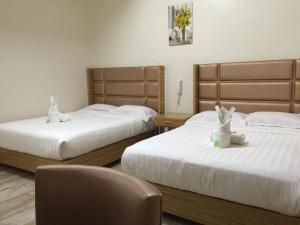 ein Hotelzimmer mit 2 Betten und einem Stuhl in der Unterkunft Meaco Hotel - Solano in Solano