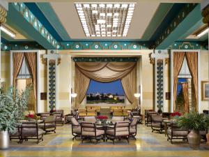 a lobby with chairs and tables and a large window at King David Hotel Jerusalem in Jerusalem