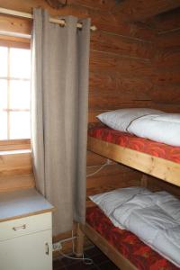two bunk beds in a cabin with a window at Fosheim Hytter in Ron