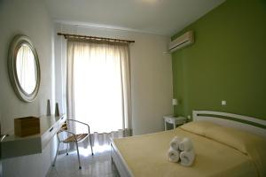 a bedroom with a bed with two towels on it at Long View Apartments in Porto Heli