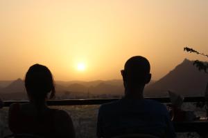 a man and a woman watching the sunset at Banjara Retreat in Udaipur