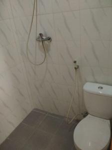 y baño con ducha, aseo y manguera. en Maven Cilandak, en Yakarta