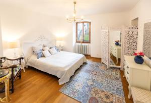 1 dormitorio con cama blanca y alfombra azul en Château du Châtelard | Unique Apartment, en Montreux