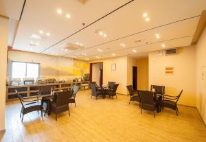 une salle à manger avec des chaises, des tables et un bar dans l'établissement GreenTree Inn Jiangsu Nantong Haimen Sanchang North Wangjiang Road Business Hotel, à Haimen