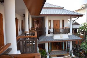 a house with a balcony with tables and chairs at Gordnuea Boutique House- SHA Extra Plus in Chiang Mai