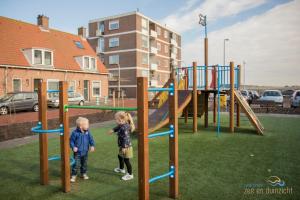 Katwijk aan ZeeにあるAppartement Zee en Duinzicht 78の遊び場で遊ぶ幼児2名