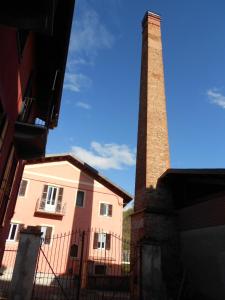 un edificio con una torre alta junto a un edificio en B&B La Ceramica Moline, en Vicoforte