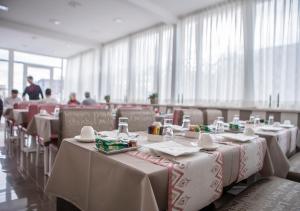 una fila di tavoli con tovaglie bianche in un ristorante di Hotel San Pietro a Napoli