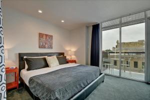 a bedroom with a bed and a large window at Littlefield Lofts #302 in Austin