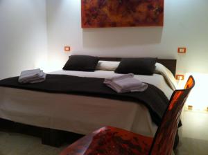 sypialnia z dużym łóżkiem z ręcznikami w obiekcie Romeo Design Rooms w Weronie