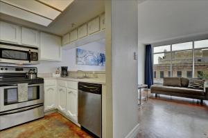 a kitchen with a stove and a couch in a room at Littlefield Lofts #302 in Austin