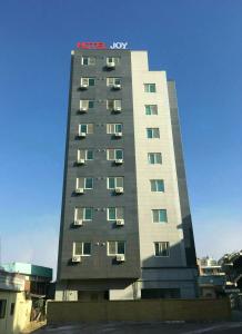 um edifício de hotel com um letreiro de Hodge Law em Hotel Joy near Camp Humphres em Pyeongtaek