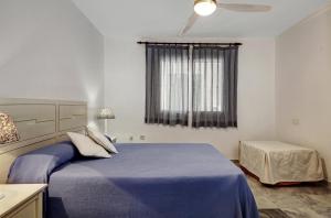 Un dormitorio con una cama azul y una ventana en Marina Playa, en La Herradura