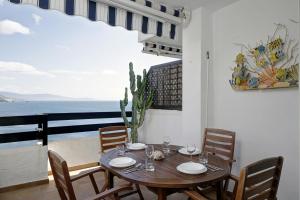 a dining room with a table and chairs with a view of the ocean at Marina Playa in La Herradura