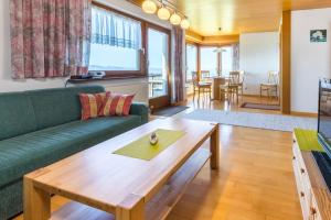 アイヒェンベルクにあるHaus Margitのリビングルーム(緑のソファ、木製テーブル付)