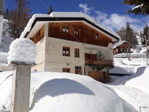 una casa con un montón de nieve delante de ella en Casa Franca trilocale en Argentera