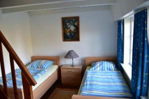 a bedroom with two beds and a lamp on a night stand at Hackerhof-Mittewohnung in Morsum