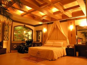 a bedroom with a bed and a chair in it at Swan Lake Motel in Guishan