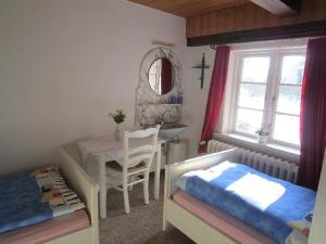 a bedroom with a table and a bed and a sink at Hackerhof-Westwohnung in Morsum