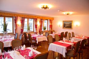 un ristorante con tavoli e sedie in una stanza di Hotel Nolda a Sankt Moritz