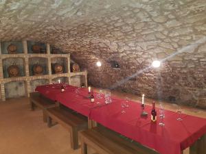 a long table in a room with wine glasses and candles at Olze Panzió in Erdőbénye