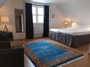 1 dormitorio con cama y alfombra azul en Linda Gård, en Yngsjö