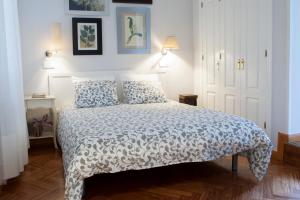 a bedroom with a bed with a white bedspread at Elegante piso junto al Museo del Prado in Madrid