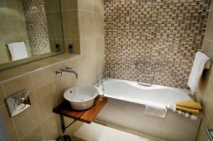 a bathroom with a bath tub and a sink at Castlemartyr Holiday Lodges 3 Bed in Castlemartyr