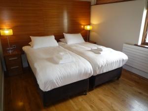 キャッスルマーターにあるCastlemartyr Holiday Lodges 3 Bedのベッドルーム1室(大型ベッド1台、白いシーツ、枕付)