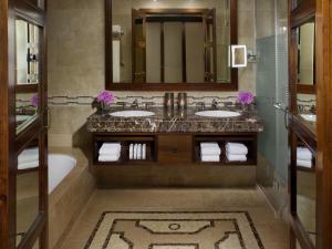 a bathroom with two sinks and a mirror at King David Hotel Jerusalem in Jerusalem