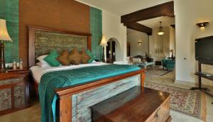 a bedroom with a large bed and a television at Mihir Garh in Rohat