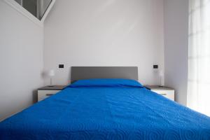 a bedroom with a blue bed with two night stands at Green House in Barletta