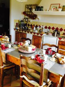 - une cuisine avec une table et des plats rouges dans l'établissement Chambre d'hôtes La Margotte, à Forcalquier