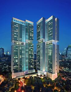 雅加达Ascott Sudirman Jakarta的夜晚的城市里的一组摩天大楼