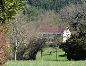 ein Haus inmitten eines Feldes mit Bäumen in der Unterkunft Auberge de La Chaloire in La Petite-Verrière