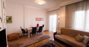 a living room with a couch and a table with chairs at Leo Lux Apartment in Kavala