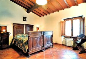 ein Schlafzimmer mit einem Bett mit einer Kommode und einem Fenster in der Unterkunft Podere Grossi in Rabatta
