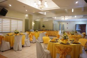 a banquet hall with tables with yellow table cloths at Stone House Quezon City in Manila