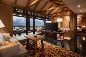 丽江Jinmao Pureal Mountain Liiang的客厅里有一张沙发和一台电视