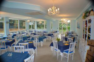 un comedor con mesas azules y sillas blancas en Hotel Paradiso Verde en Marina di Bibbona