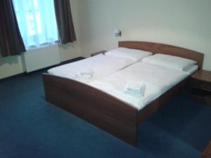 Una cama en una habitación con dos platos. en Parkhotel Centrum en Spišská Nová Ves