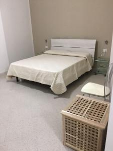 1 dormitorio con 1 cama, 1 silla y 1 cesta en B&B Aliga, en Porto Empedocle