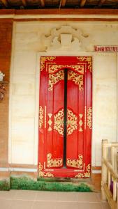 a red door on the side of a building at Rice padi Artha in Ubud