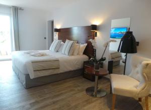 ポルト・ヴェッキオにあるIsulella Hotel & Restaurantのベッドルーム(大型ベッド1台、椅子付)