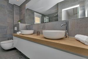 a bathroom with two sinks on a wooden counter at Penthouse Bella Vista Makarska in Makarska +51 photos