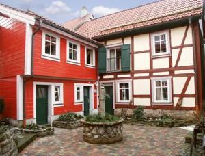 two red and white houses with a stone courtyard at Pension Picco-Bello in Clausthal-Zellerfeld